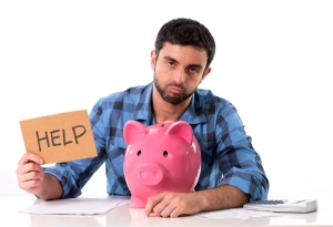 sad worried man in stress with piggy bank in bad financial situation